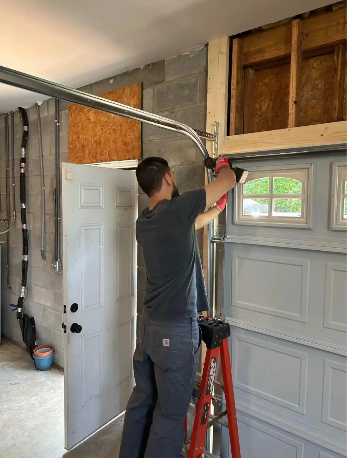 Technician on a ladder servicing a garage door